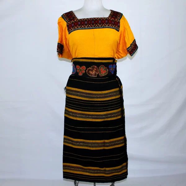 Traje típico de Guatemala, combinación de 3 piezas. Incluye el huipil, corte y la faja. Multicolor amarillo anaranjado y negro. Trae fracciones de otros colores incluyendo amarillo, rojo y celeste.